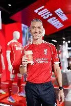 A person in a red shirt holding a cup AI-generated content may be incorrect.